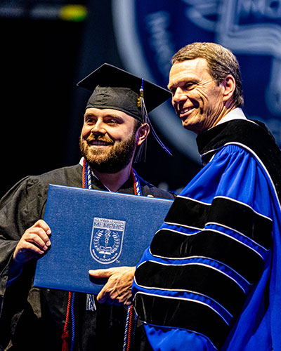 President Bill Clinton hands student diploma during commencement ceremoy