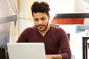 student on laptop in cafe