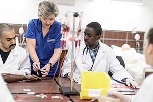 Nursing teacher with 2 students learning how to set up IVs