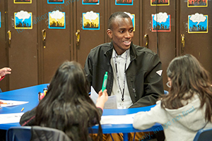 young teacher at table with elementary students
