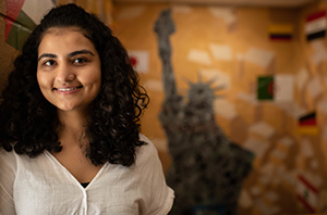 student in front of international wall