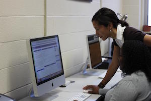 student standing looking at the computer screen
