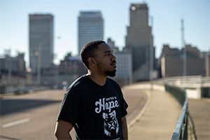 UofM student in foreground, city of Memphis skyline in the background
